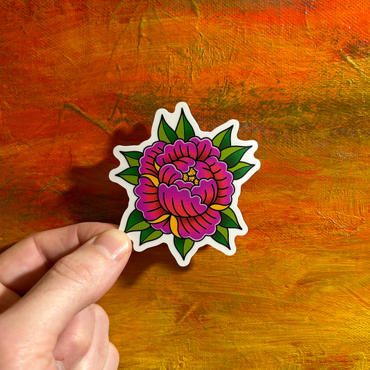 A vibrant die cut sticker of a magenta peony surrounded by little green yellow shaded leaves with yellow highlights on the flower.