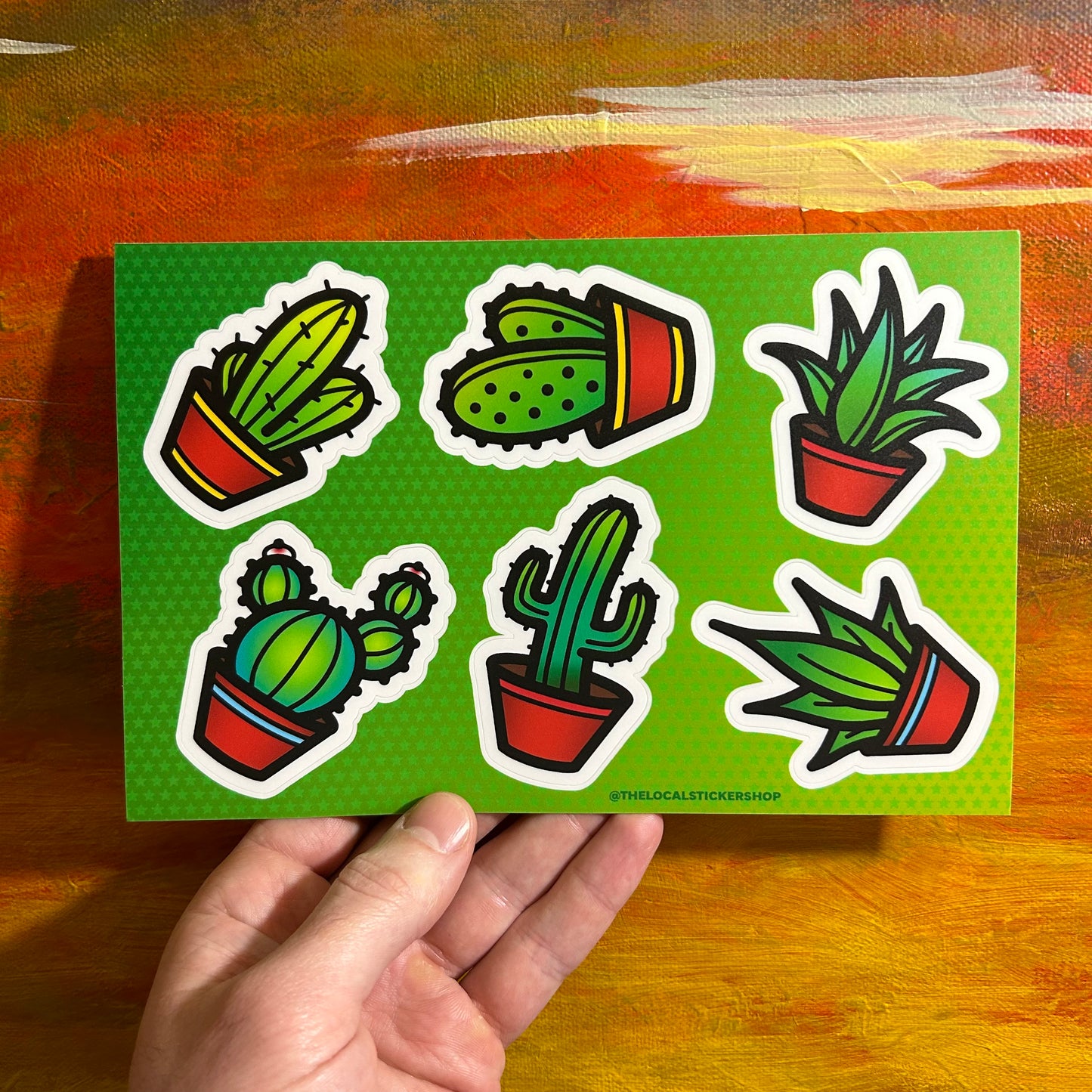 A sheet of stickers with 6 separate stickers of illustrative, bold heavy black lines cactus in red brown pots.