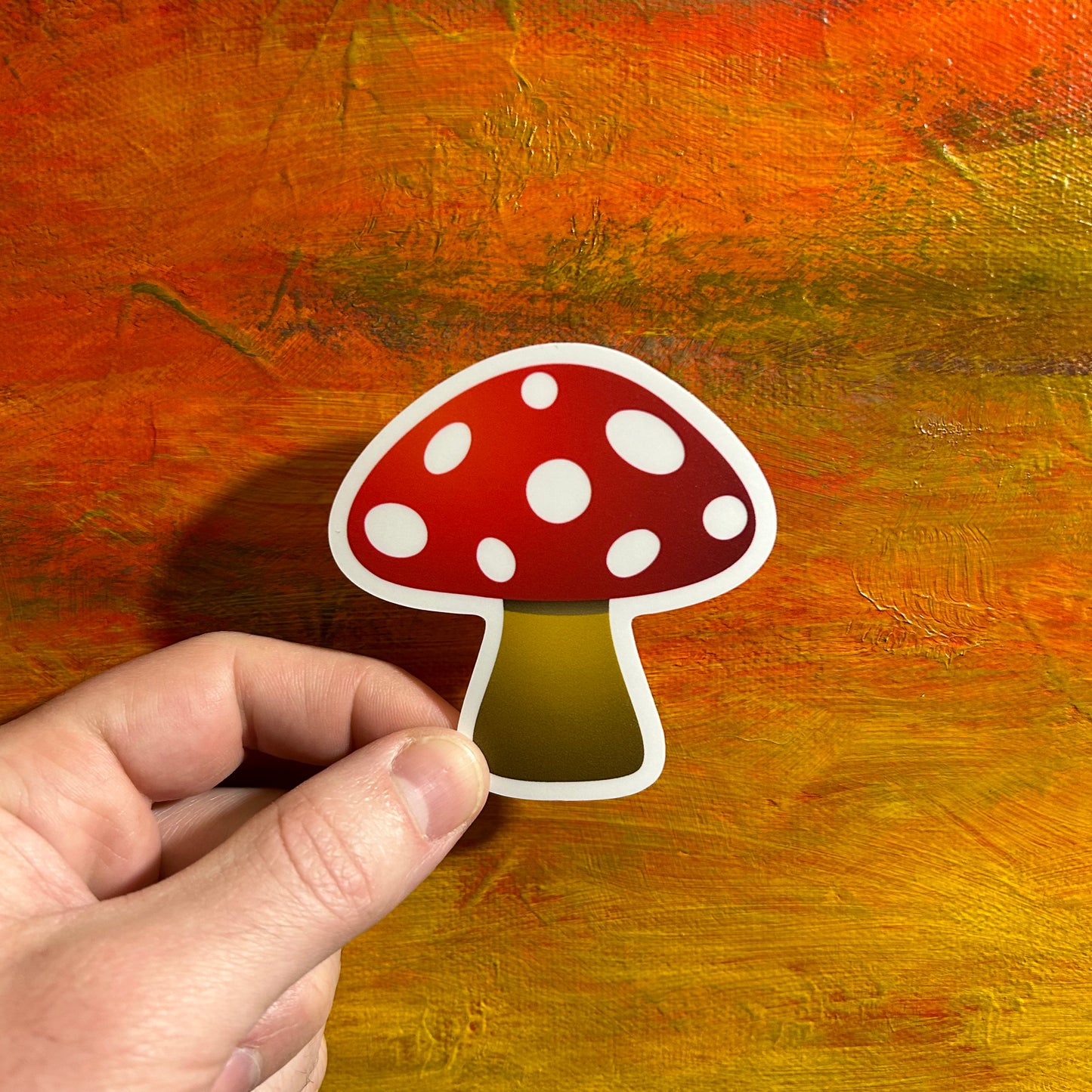 Illustrative comical die cut sticker of a bright beautiful red mushroom with a brown hued stem.